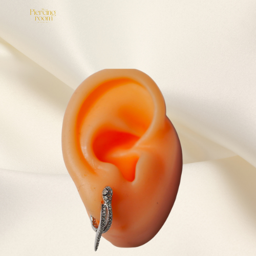 Snake Huggie Hoops gedragen in oorlel. Luxe oorringen met slangmotief en sprankelende zirconia’s, verkrijgbaar in goud of zilver.