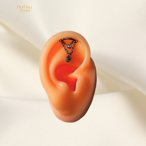 Dual Chain Teardrop Hidden Helix piercing van titanium in zilver, met dubbele ketting en zirconia details. Gedragen in het oor als stijlvolle helix piercing.